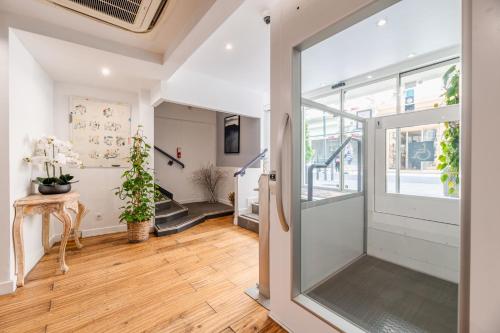 a hallway with a sliding glass door and a staircase at Hôtel Hoche in Cannes
