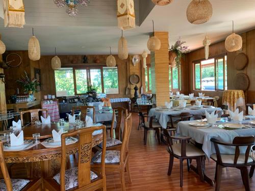 a restaurant with tables and chairs in a room at Butsaba Garden Resort in San Pāyang