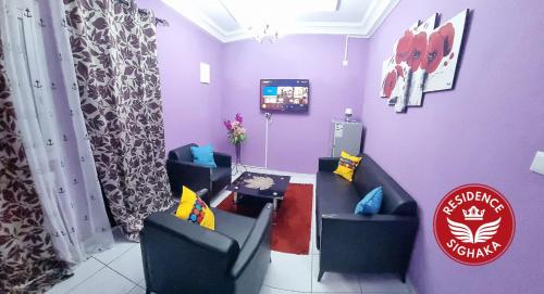 - une salle d'attente avec 2 chaises et une télévision dans l'établissement Residence Sighaka - Gold Apartment - WiFi, Gardien, Parking, à Douala