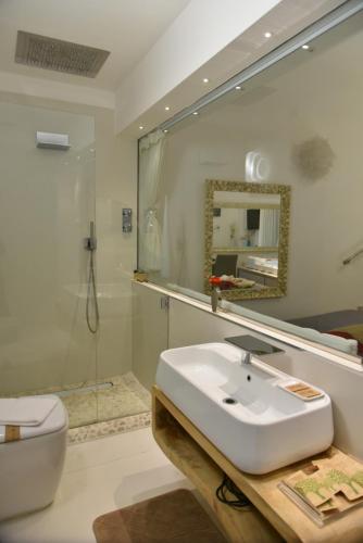 a bathroom with a sink and a toilet and a mirror at Conte Max Rooms in Termoli