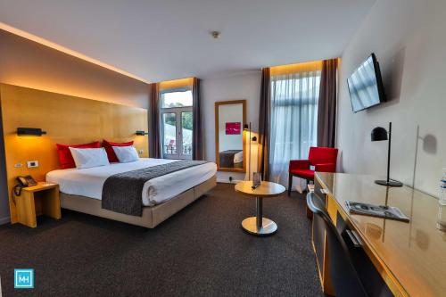 a hotel room with a bed and a television at Hotel De La Couronne Liege in Liège