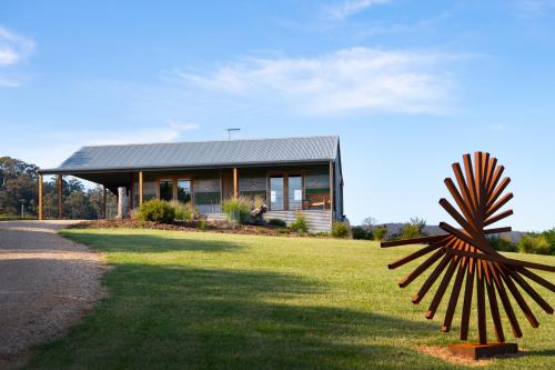 a house with a palm tree statue in front of it at Fellcroft Farmstay in Cobaw