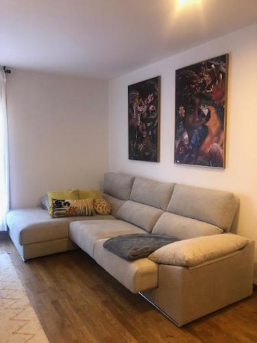 a living room with a couch and paintings on the wall at Un lindo piso acogedor para desconectar en Sort in Sort