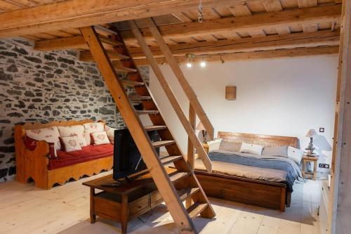 a loft bedroom with a bed and a staircase at Gîte ferme en permaculture avec ses animaux in Sixt