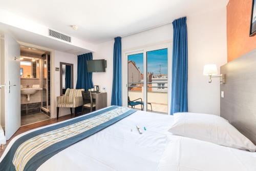 um quarto com uma cama e vista para uma casa de banho em Hôtel Hoche em Cannes
