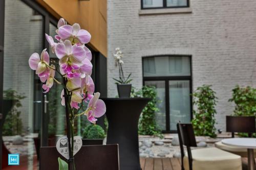 a couple of vases with purple flowers in them at Hotel De La Couronne Liege in Liège