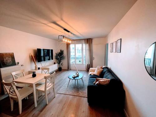 a living room with a couch and a table at LOTUS- 4 min de Walt Disney-Arrivée autonome-Parking et Wifi gratuit-Proche de toutes commodités 5Min de la vallée village in Chessy