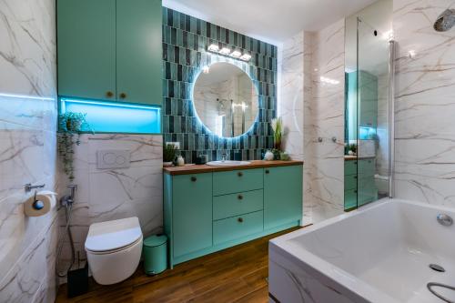 een badkamer met een bad, een toilet en een wastafel bij Zielony Apartament Pod Żaglami in Zegrze Południowe
