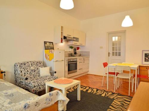 a living room with a kitchen and a table with chairs at Apartmani Cmiljina in Sveti Juraj