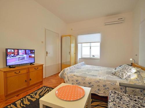 1 dormitorio con 1 cama y TV de pantalla plana en Apartmani Cmiljina, en Sveti Juraj