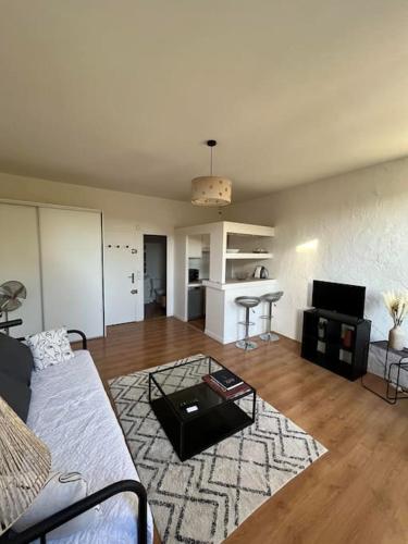 un salon avec un canapé et une table dans l'établissement So'Conciergerie - Charmant studio en plein centre., à Cassis