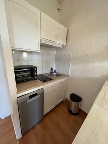 une petite cuisine avec un évier et un micro-ondes dans l'établissement So'Conciergerie - Charmant studio en plein centre., à Cassis