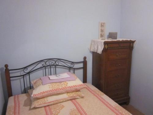 a bedroom with a bed and a wooden dresser at Apartments Radnić in Pag