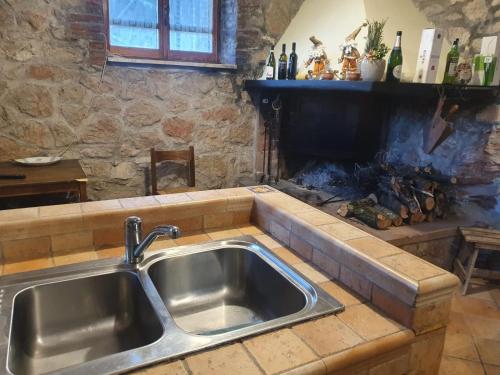 a kitchen with a sink and a fireplace at Casa di Nonna Luciana 