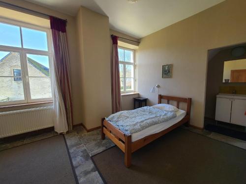 a bedroom with a bed and a large window at Family-friendly accommodation in the forges of Orval opposite the abbey in Abbaye dʼOrval