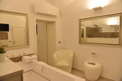 a white bathroom with a toilet and a mirror at Conte Max Rooms in Termoli