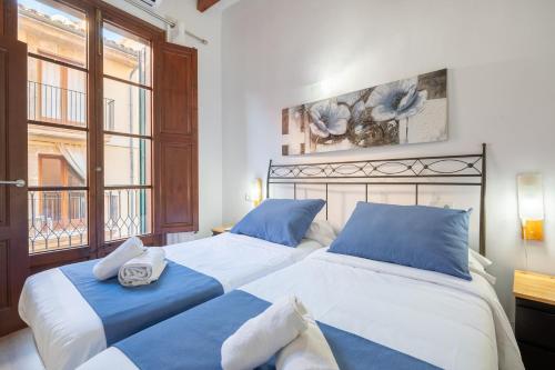 2 letti in una camera da letto con blu e bianco di Holiday Palma Apartments - TI a Palma de Mallorca