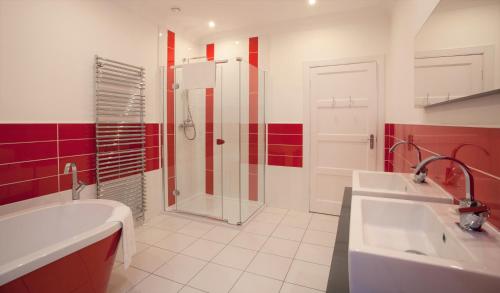 a bathroom with a shower and two sinks and a tub at Cherry Blossom Cottage in Cupar