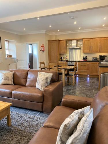 a living room with two couches and a kitchen at Cherry Blossom Cottage in Cupar