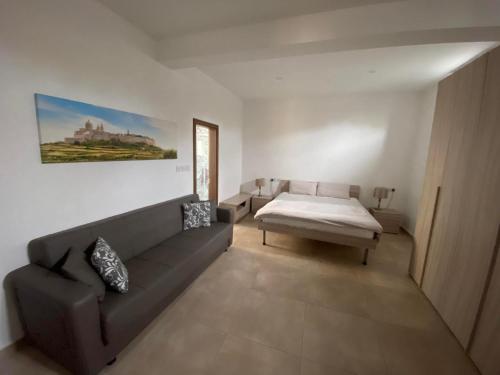 - un salon avec un canapé et un lit dans l'établissement Palazzo Leonardo, à Il-Furjana