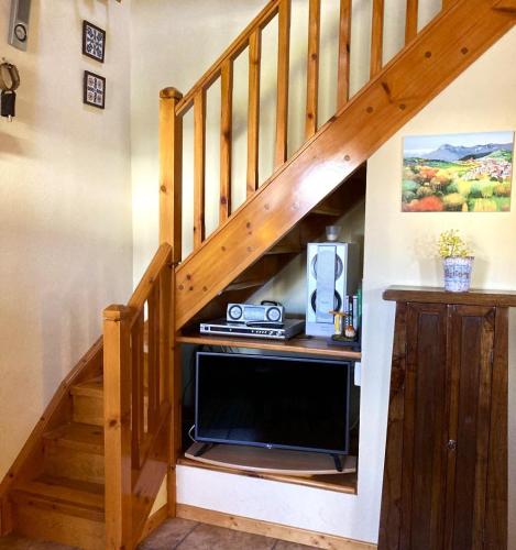 Cette chambre est dotée d'un escalier, d'une télévision et d'un bureau. dans l'établissement Bonita casa adosada con gran jardín, à Osséja