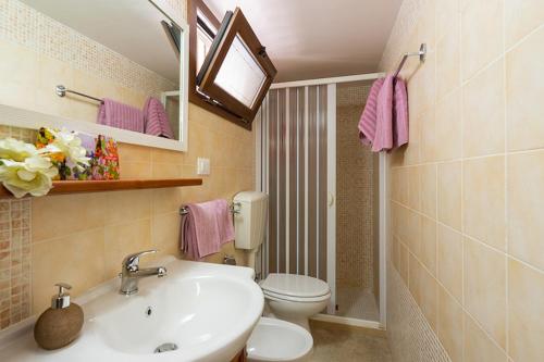 bagno con lavandino e servizi igienici di L' ATTICO CastroSalento a Castro di Lecce