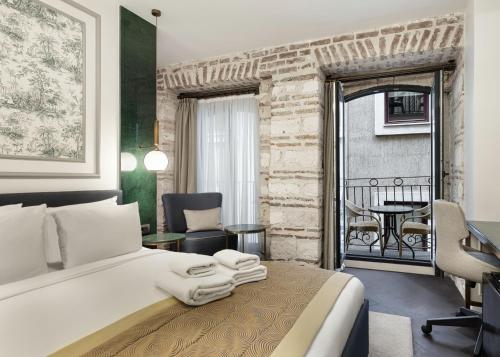 Pera Rasso Hotel في إسطنبول: غرفة نوم بسرير ابيض كبير وطاولة