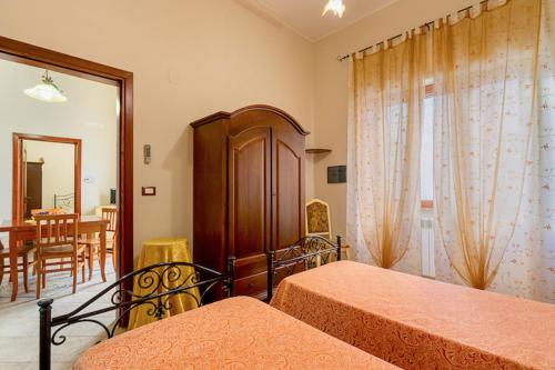a bedroom with two beds and a dining room at Appartamento SupersanoSalento in Supersano