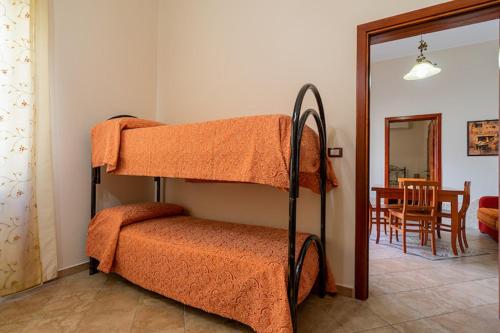 a bedroom with two bunk beds and a dining room at Appartamento SupersanoSalento in Supersano