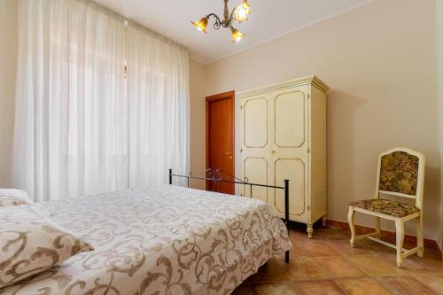 a bedroom with a bed and a cabinet and a chair at Appartamento SupersanoSalento in Supersano