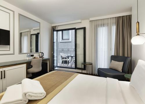 um quarto de hotel com uma cama grande e uma varanda em Pera Rasso Hotel em Istambul