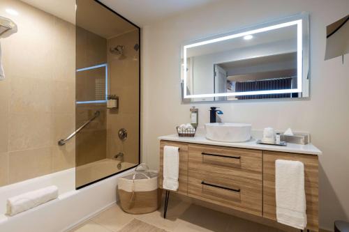 uma casa de banho com um lavatório, um chuveiro e um espelho. em Wyndham Palmas Beach and Golf Boutique Resort em Humacao