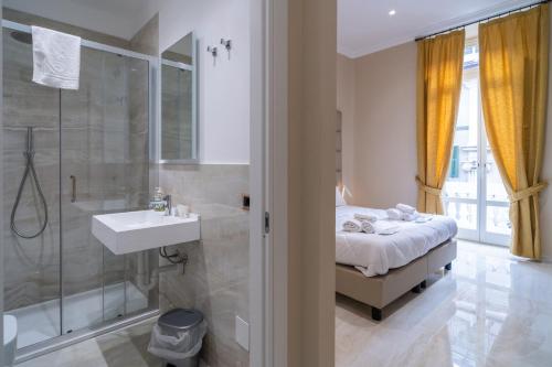 bagno con letto, doccia e lavandino di Correnti Boutique Hotel Gold a Sanremo