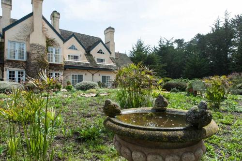 a garden with a bird bath in front of a house at Seal Cove Inn in Half Moon Bay