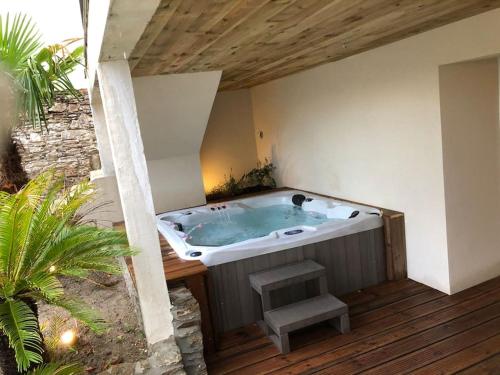 un bain à remous dans un bâtiment avec un banc dans l'établissement Les Palmiers. Charme, spa et massage en vignoble nantais, au Pallet