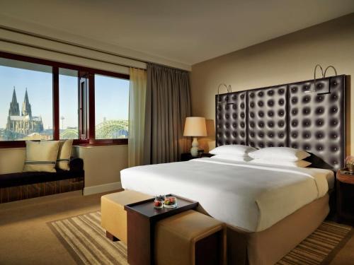 a hotel room with a large bed and a large window at Hyatt Regency Köln in Cologne