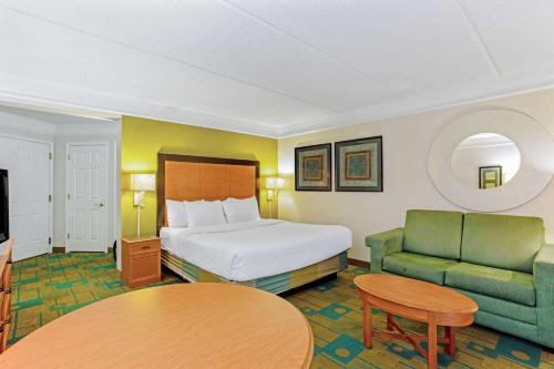 a hotel room with a bed and a couch and a table at La Quinta by Wyndham Orlando I Drive/Conv Center in Orlando