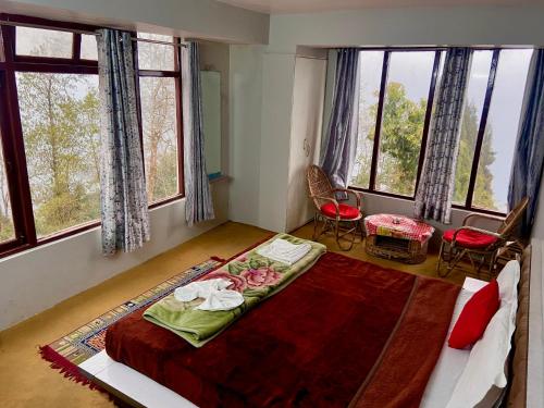 a bedroom with a bed in a room with windows at Hotel Snow Valley Rooftop in Pelling