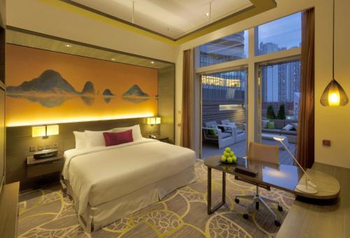 香港的住宿－香港九龍東皇冠假日酒店，酒店客房配有一张床、一张书桌和一张书桌。