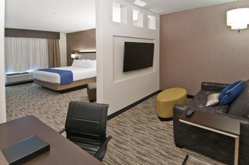 a hotel room with a bed and a couch at Holiday Inn Austin Airport by IHG in Austin