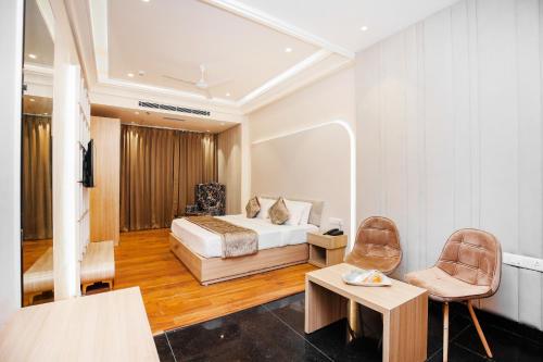 a hotel room with a bed and two chairs at Hotel Euphoria Green in Amritsar