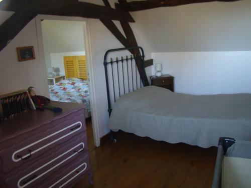 Schlafzimmer mit einem Bett, einer Kommode und einem Spiegel in der Unterkunft La maison d'Agnes en Haute Bourgogne in Jully