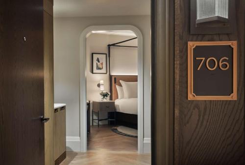 a hotel room with a bed and a door with a sign at Pendry Washington DC - The Wharf in Washington