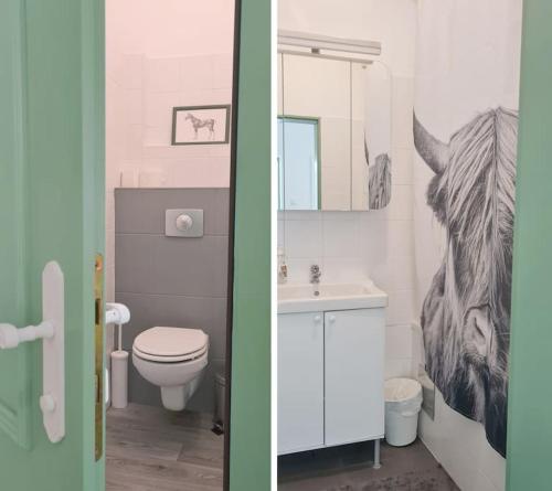 a bathroom with a toilet and a sink with a horse picture at Cosy Family Apartment in Reichenau