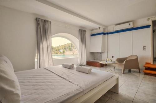 a bedroom with a large bed with a large window at Villa Nikolitsa with private beach in Megara