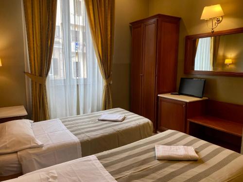 a hotel room with two beds and a television at Hotel Giolitti in Rome