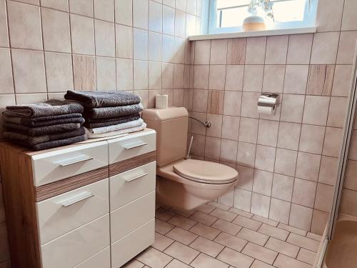 a bathroom with a toilet and towels on a counter at Musi Appartements in Schönberg im Stubaital