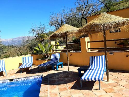 three blue and white chairs and a swimming pool at Los Montes Traditional Casa with private pool in Viñuela