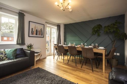 a living room with a dining room table and a couch at Upton Grange Townhouse in Chester