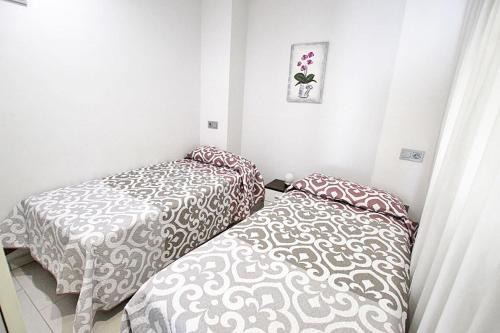 two beds in a small room with at Apartamento 10 Marjal Playa Centro de Guardamar in Guardamar del Segura